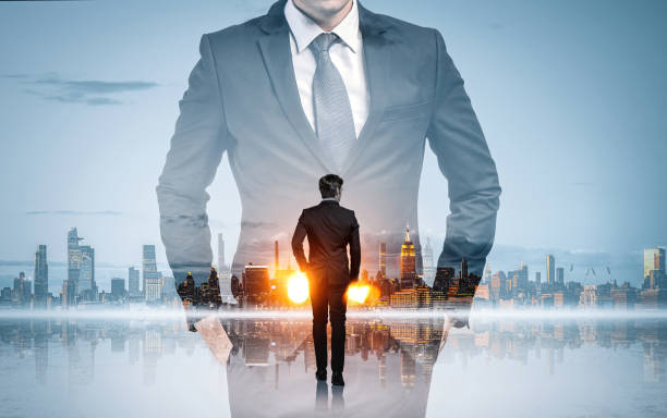 istock Businessman with hands in pocket and office skyscrapers, panoramic view 1360948818