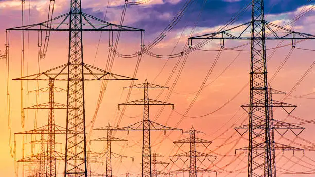 High voltage pylons in the evening sun 
Concept for electricity generation, rising electricity prices, environmental issues, climate change