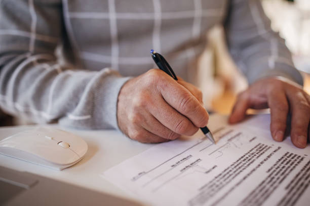 istock Filling in a paper document in the office 1360954781