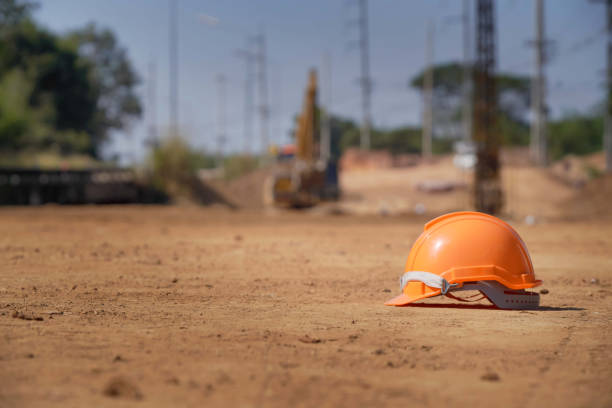 Tanami Desert, Northern Territory, Australia, January 7, 1987: View of two workers wearing orange safety vests and white hard hats discussing work progress on the floor of an open cut gold mine pit