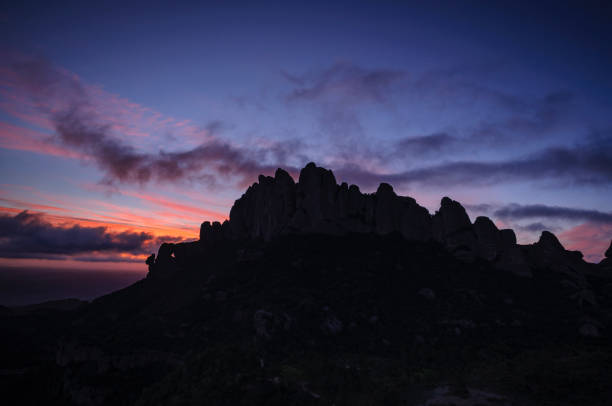 Montserrat west face and Roca Foradada seen from Sant Pau Vell de la Guàrdia at sunrise with red sky (Barcelona province, Catalonia, Spain) stock photo