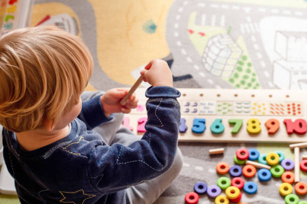 赤ちゃんの幼児早期発達。木製のスタックとカウント虹色の学習ゲーム。子供は色と数字を学びます - toddler ストックフォトと画像