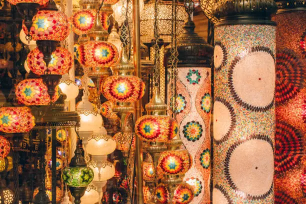 Photo of Traditional turkish or moroccan light mosaic lamp. Colorful stained glass lamp against defocused souvenir shop background with copy space. Popular souvenir and ideas for present