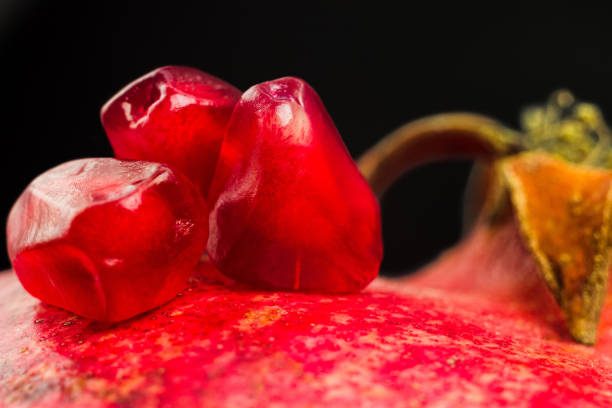 istock Garnet fruit seeds macro shot. Pomegranate fruit and seed close up on black background. 1361005373