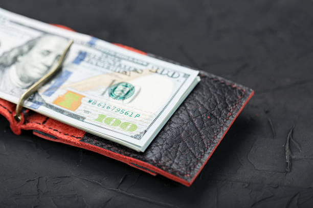 istock Red purse with new dollars on a black background. 1361005442