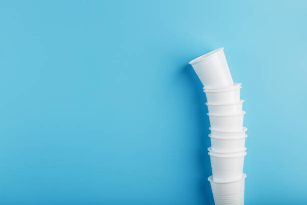 istock Plastic cups of disposable tableware in the shape of a tower on a blue background. 1361005752