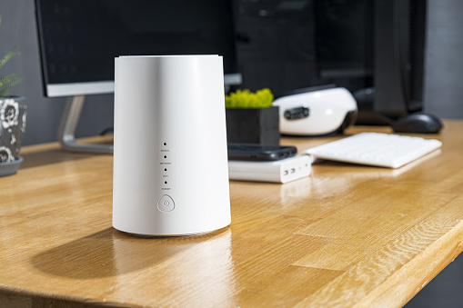 White modern modem connected to the Internet stands on the office desk