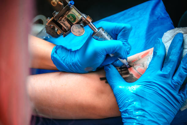 istock Professional tattoo artist makes a tattoo on the client's tattoo studio 1361013140