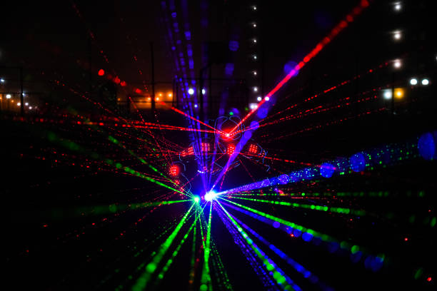 istock multi-colored laser beams. man laserboy. laser lines in the dark 1361013336