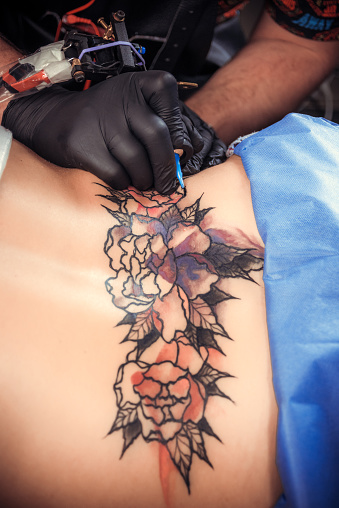 Tattooer showing process of making a tattoo.