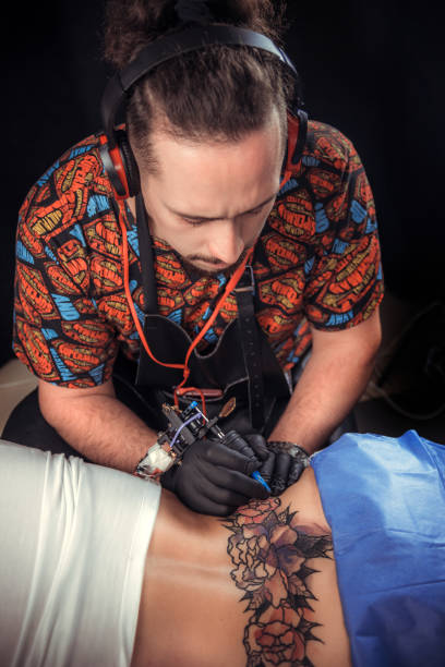 istock Tattoo artist designs a tattoo 1361018256