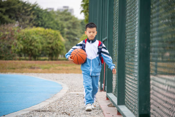 Pupils holding basketball on the playground