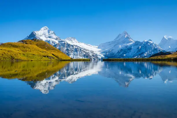 Bachalpsee, Grindelwald, Switzerland. High mountains and reflection on the surface of the lake. Landscape in the highlands in the summertime. Photo in high resolution.