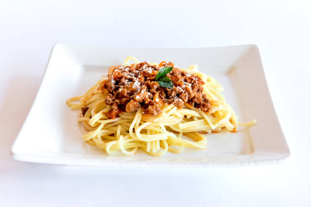 istock Spaghetti bolognese served on a white plate on a white background with basil. 1361026203