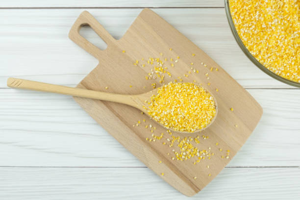 istock Wooden spoon with corn grits on a wooden cutting board 1361028057