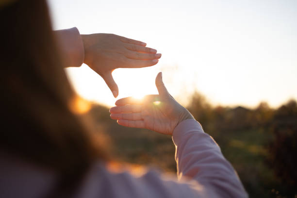 istock Future planning idea concept, woman making frame round the sun with her hands in sunrise, business concept 1361031296