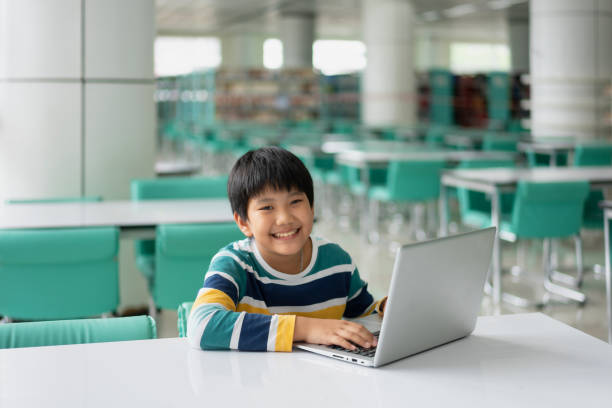 istock Portrait of Cute Asian boy studying or playing game with laptop computer 1361032026