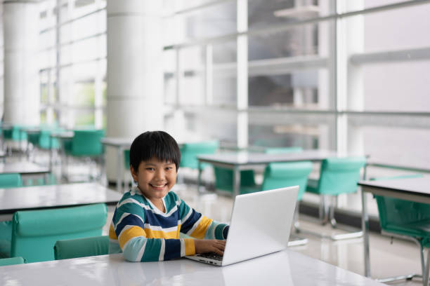 istock Portrait of Cute Asian boy studying or playing game with laptop computer 1361032056