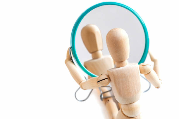 istock Wooden dummy looks at its reflection in the mirror 1361032691