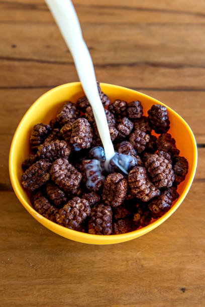 istock Pouring milk into chocolate cornflakes balls Breakfast with milk and cornflakes. 1361032764