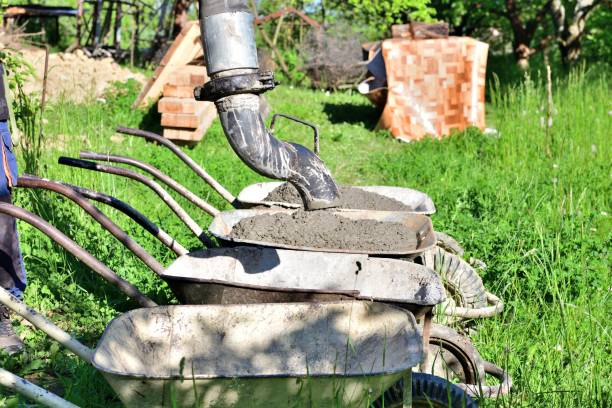 The concrete remains from the pump machine are poured into the wheelbarrow stock photo