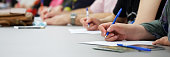 istock The girls write with fountain pens on sheets of paper. Concept for college exam, filling out forms and questionnaires. Web banner. Close-up 1361035509