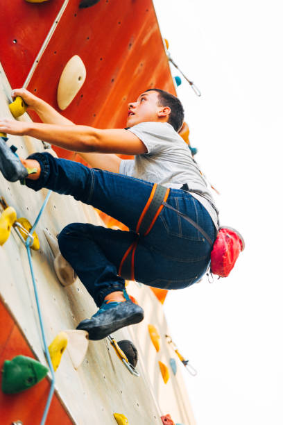 istock Young man exercising in climbing gym 1361039337