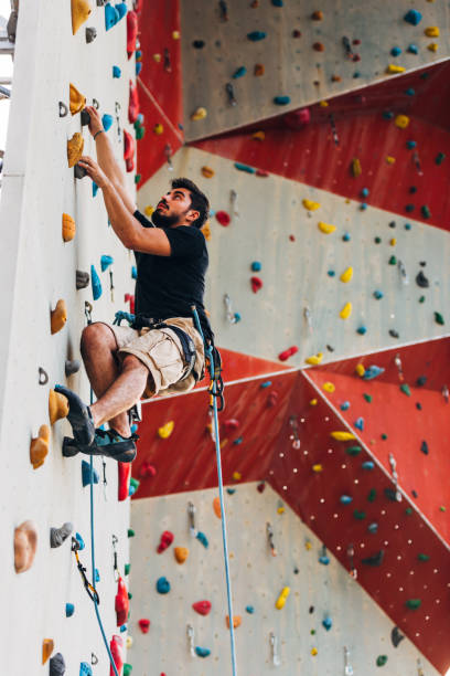 istock Man climbing wall with grips 1361041563