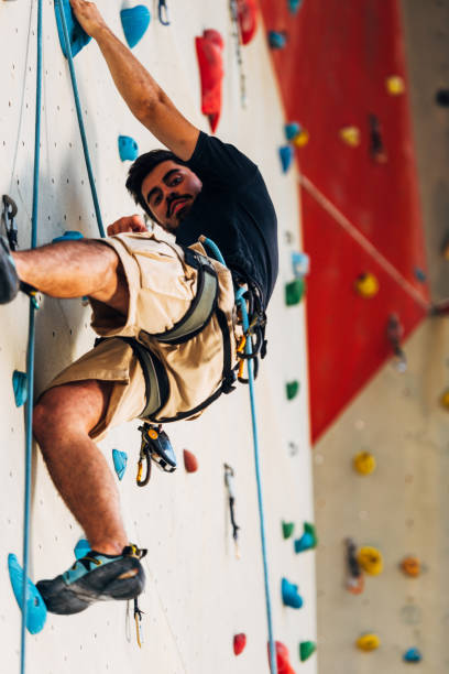 istock Young man exercising in climbing gym 1361041566