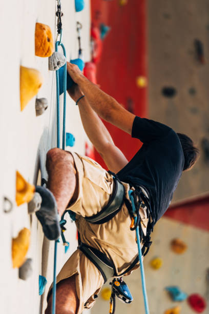 istock Man climbing wall with grips 1361041570
