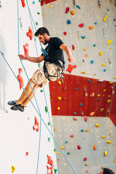 istock Muscular man descending down on a big wall 1361041575