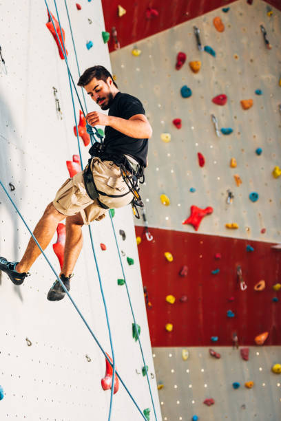 istock Young sporty man descend down on practice mount wall outdoor 1361041579
