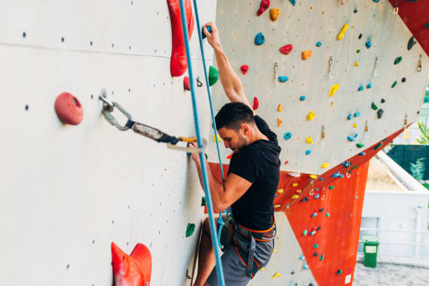 istock Muscular man practicing rock-climbing on a rock wall 1361042095