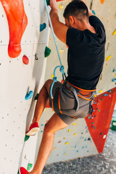 istock Muscular man practicing rock-climbing on a rock wall 1361042105