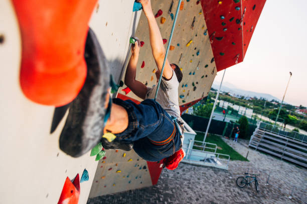 istock Sportive man climbs up on artificial rock wall 1361048995
