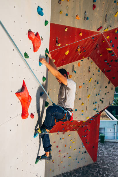 istock Muscular man practicing rock-climbing on a rock wall 1361048998