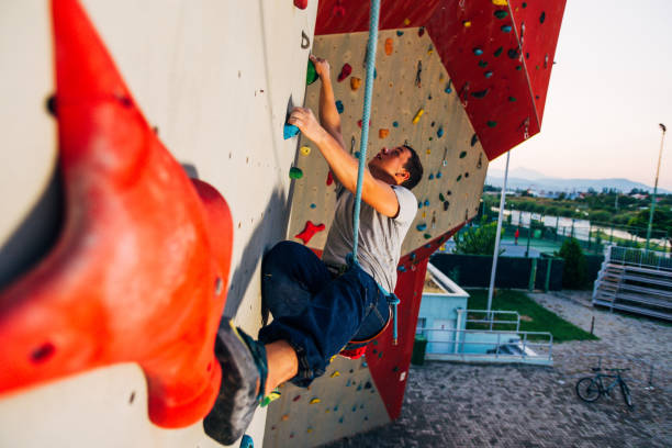 istock Young man climbing artificial rock wall at gym 1361049020