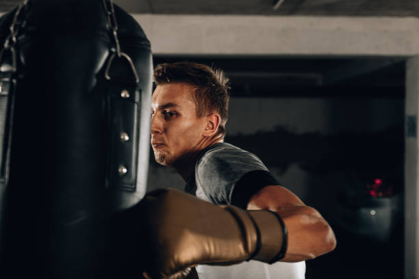 istock Kickboxer training in the garage kicking the punch bag 1361049520