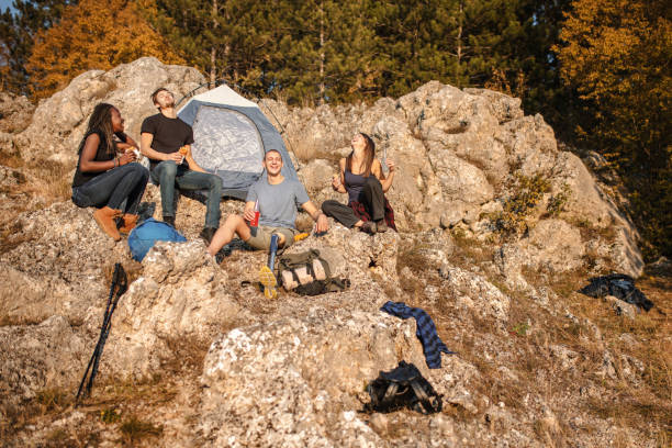 istock Disabled young man with artificial leg is resting with friends after hiking 1361050406
