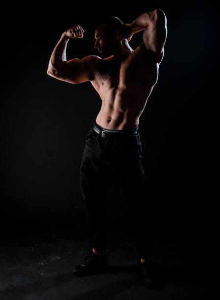 istock Personal fitness trainer. Strong man flexing his muscles 1361050501
