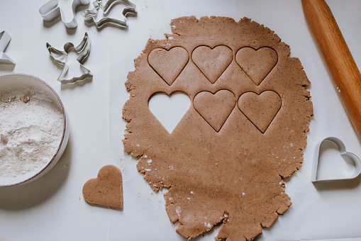 The process of cutting cottage cheese cookies with molds from soft dough rolled out on a board. Cooking delicious homemade cakes