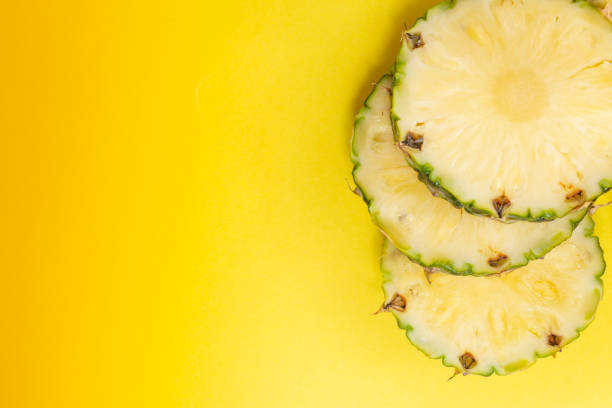 istock pieces of sliced pineapple on a yellow background top view. Rape Pineapple fruit 1361051902