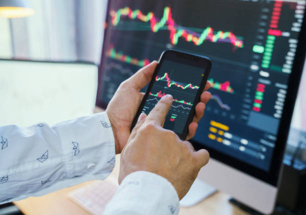 istock Businessman analyzing crypto currency market graphs on smartphone screen at home. Bitcoin / Cryptocurrency concept 1361055350