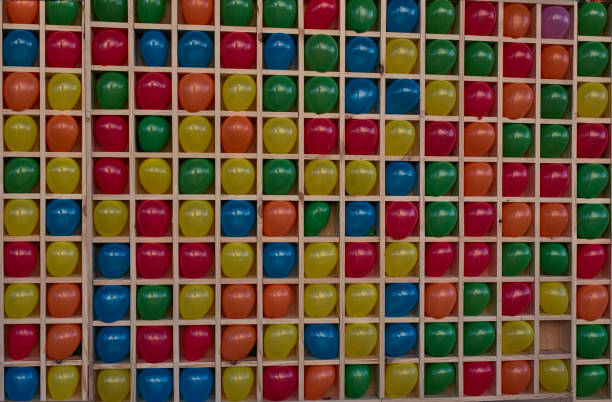 muchos globos de colores en jaulas cuadradas para jugar dardos. - rubber dart fotografías e imágenes de stock