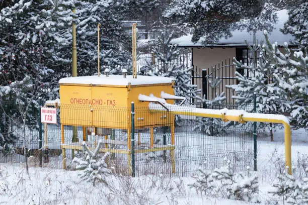 Gas equipment in winter village and two same russian inscriptions:  "flammable - gas". Gasification of settlements, heating in cold season concept.
