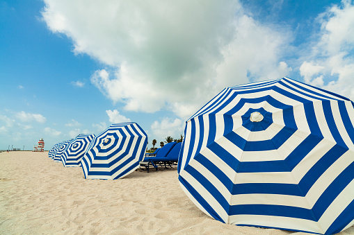 Lounge chairs and umbrellas at lonely beach.