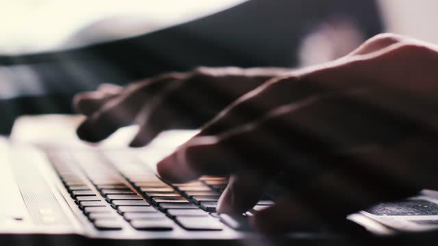 Man Working and Typing on Laptop Computer at Desk Office. Closeup. 4K Resolution.