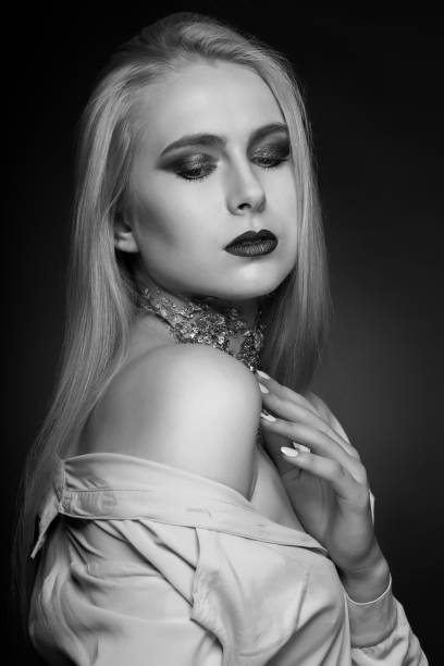 istock Monochrome beauty shoot: passionate blond model posing with foil on her neck 1361086089