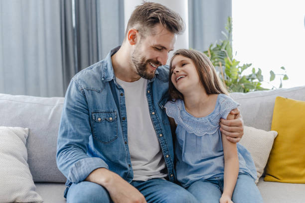 istock Father and daughter at home on the couch 1361086750