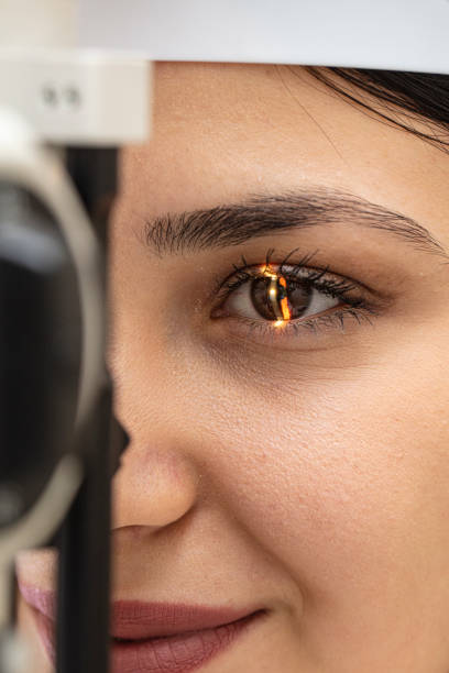il medico oftalmologo maschio sta controllando la visione oculare della bella giovane donna nella clinica moderna. medico e paziente in clinica oftalmologica. - optometrie foto e immagini stock